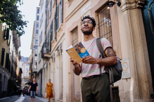 Young man using city guide while exploring European city Solo traveler city break, Italy city of Milan wonderlust stock pictures, royalty-free photos & images