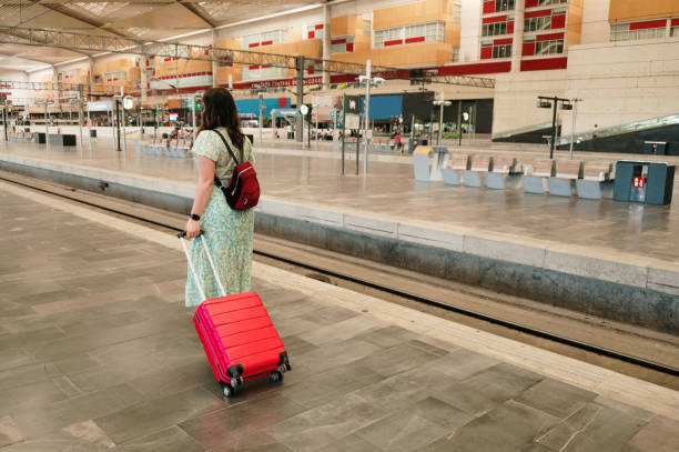istock Woman with suitcase in a railroad station 1406868956