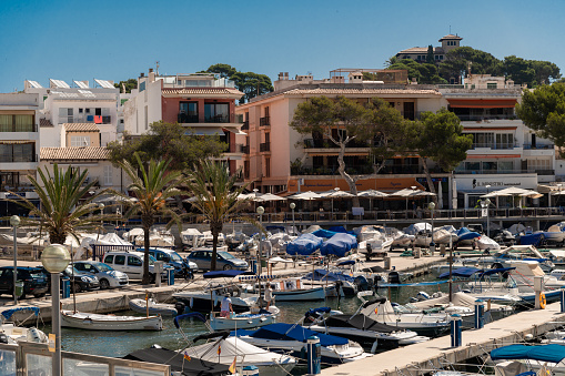 Cala Ratjada, Mallorca, Spain; June 25th, 2022: Port in Cala Ratjada center with residential buildings and a promenade