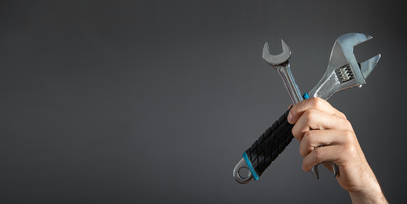 Male hand holding a wrench. Maintenance