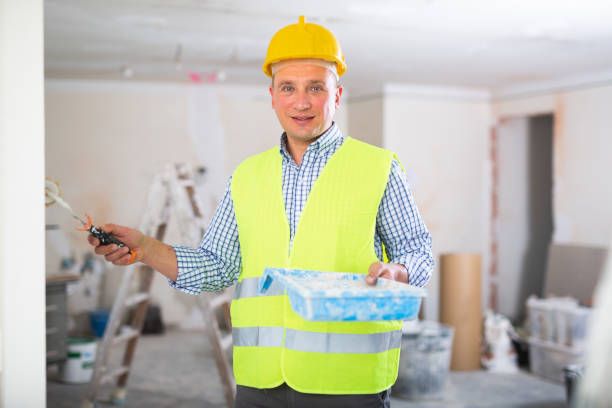 istock Positive builder painting wall in apartment 1406871146
