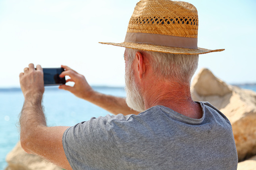 Male photographer holding professional digital camera and signaling ok with thumbs up.