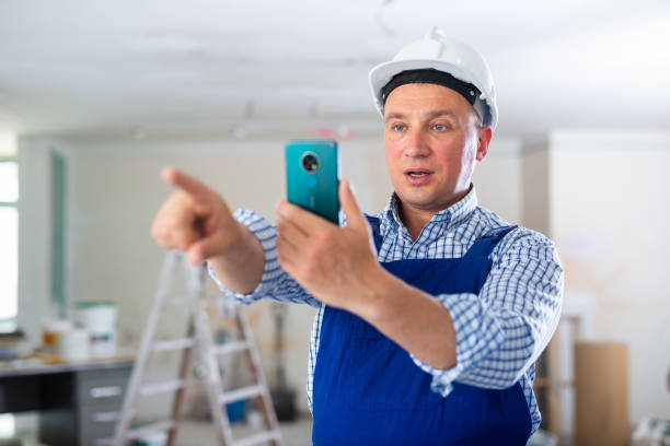 istock Man construction worker photographing with smartphone 1406871686