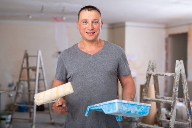 istock Portrait of positive man painter with paint roller 1406871828