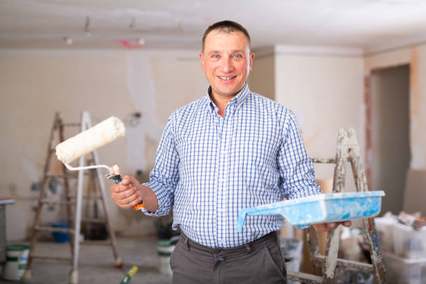 istock Portrait of positive man painter with paint roller 1406871831