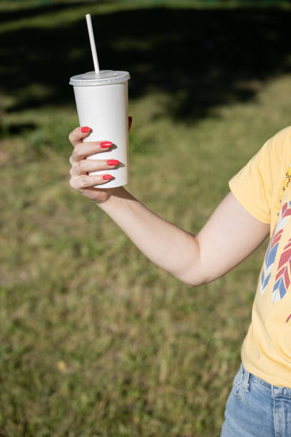 istock woman's hand holding a white paper glass with a straw 1406874944