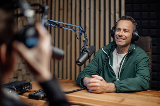 homem apresentador falando com microfone e entrevistando um homem para um podcast de rádio. - locutor de radio - fotografias e filmes do acervo