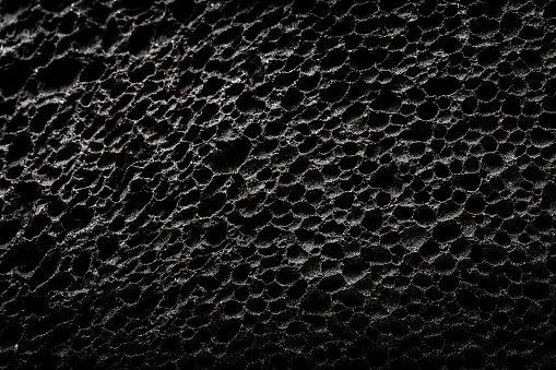 Extreme closeup of a black pumice stone pattern background