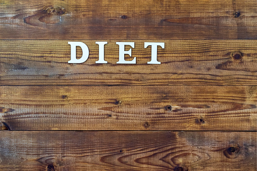 Diet. Text in block letters on a wooden table.Free space for design.