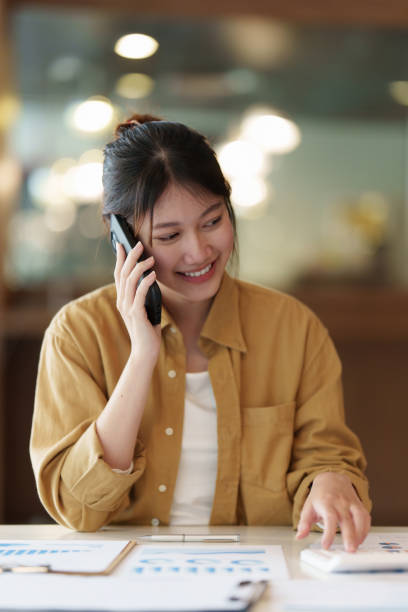 istock Image of Young woman with a cell phone working online on laptop computer. studying or working from home online concept. 1406876130