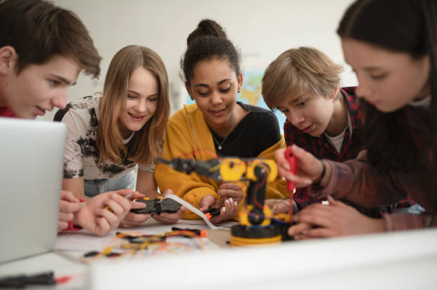 istock Group of students building and programming electric toys and robots at robotics classroom 1406876449
