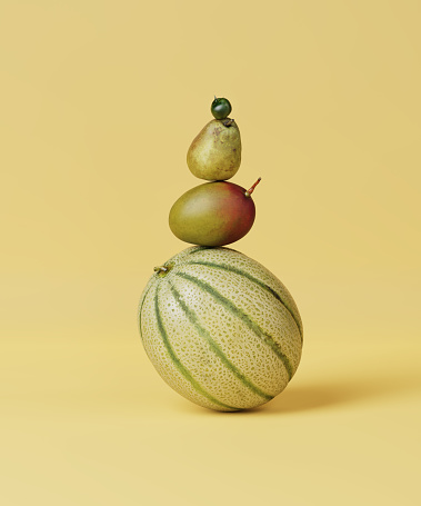 Still life pyramid of melon, pear, mango and tomato on a yellow background. Ripe fruit and vegetable. Summer mood. 3d render, 3d illustration.