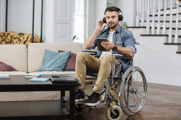 istock Disabled man in headphones using tablet at apartment 1406879282