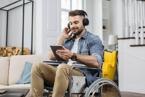 istock Disabled man in headphones using tablet at apartment 1406879290