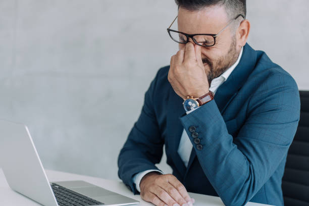 istock Stressed businessman having headache while working on laptop in the office. 1406880342