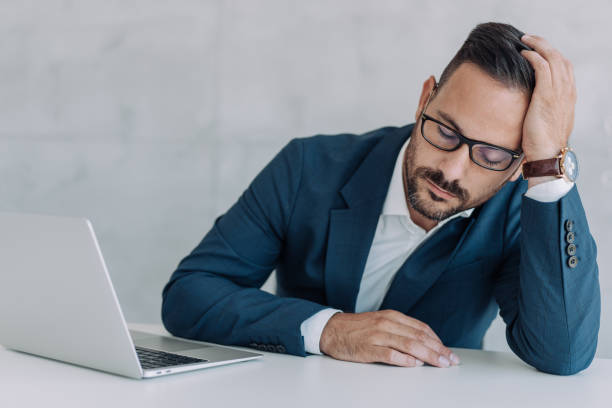 istock Businessman napping at desk in the office. 1406880343