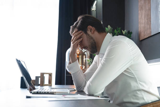 istock Frustrated stressed businessman feel tired having migraine during working. Exhausted man having headache and problem 1406880546