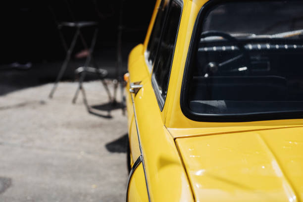 An old classic Chevy car is shown from a close-up perspective. The image is taken from the front looking back from the automobile's left side. The shiny new yellow paint job makes the car look great.