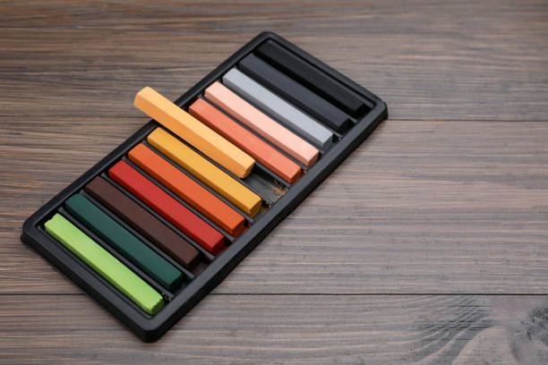 istock Colorful pastels in tray on wooden table, space for text. Drawing materials 1406881964