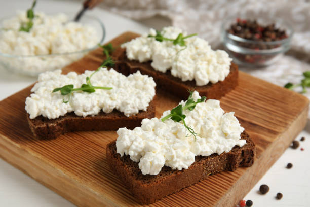 istock Bread with cottage cheese and microgreens on white table, closeup 1406882032