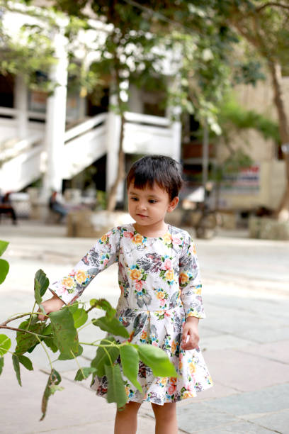 istock Baby girl playing with nature leaf 1406882083