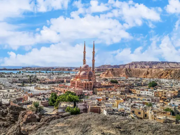 View from the mountain to the old city of Sharm El Sheikh in the valley with the Red Sea on the horizon, Egypt. Exotic urban panorama of Egyptian tourist town