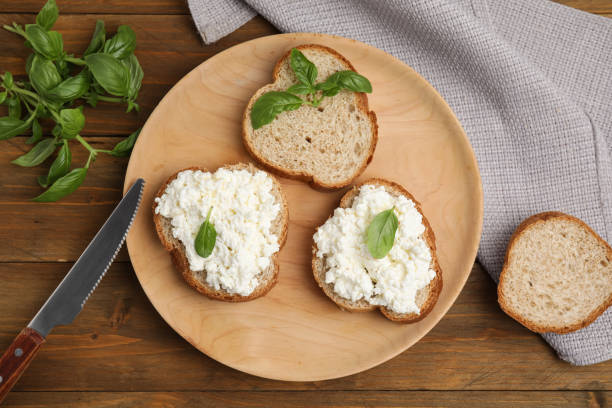 istock Bread with cottage cheese and basil on wooden table, flat lay 1406882312