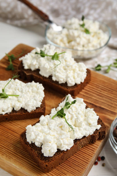 istock Bread with cottage cheese and microgreens on wooden board, closeup 1406884201