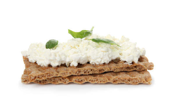 хрустящие крекеры с творогом и базиликом на белом фоне - ricotta cheese freshness white стоковые фото и изображения
