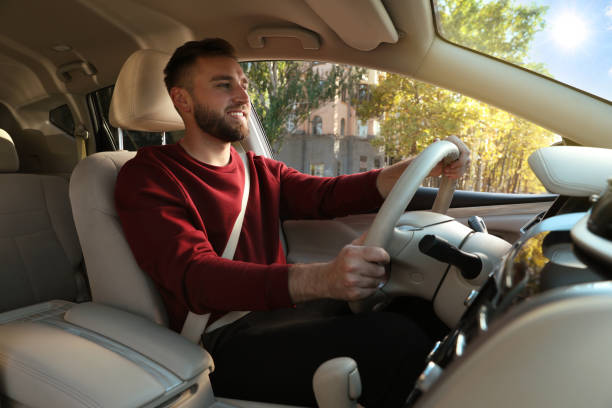 istock Handsome young driver sitting in modern car 1406887405