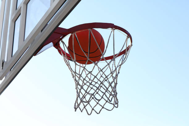 istock Basketball ball and hoop with net outdoors on sunny day 1406887463