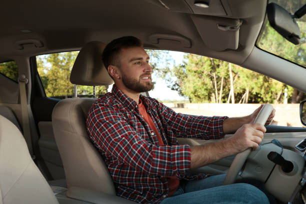 istock Handsome young driver sitting in modern car 1406887493