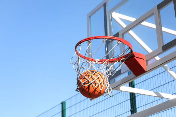 istock Basketball ball and hoop with net outdoors on sunny day 1406887508