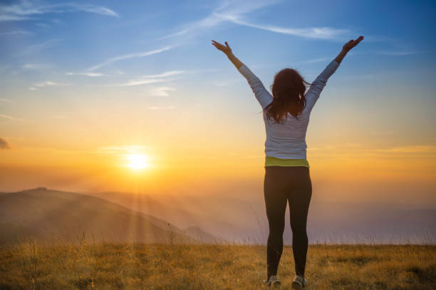 istock Young woman jumping at sunset mountains 1406888007