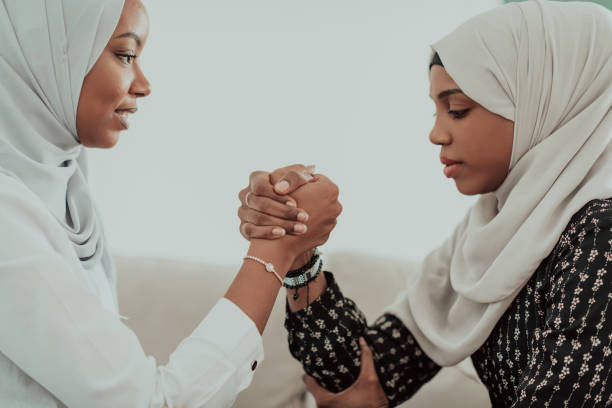 afrikanische frau armdrücken konflikt konzept, meinungsverschiedenheit und konfrontation tragen traditionelle islamische hijab-kleidung. selektiver fokus - conflict competition arm wrestling business stock-fotos und bilder