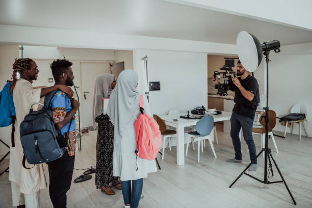 A videographer in a home studio captures a group of modern students with a professional camera. A videographer in a home studio captures a group of modern students with a professional camera. High-quality photo muslim photographer stock pictures, royalty-free photos & images