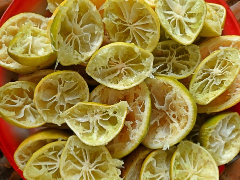 Bowl of bunch of lemons and halves on a marble surface