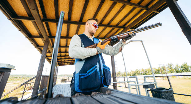 erwachsener trapshooter baut seine schrotflinte zusammen, bevor er mit dem schießen beginnt - sport clipping path handgun pistol stock-fotos und bilder