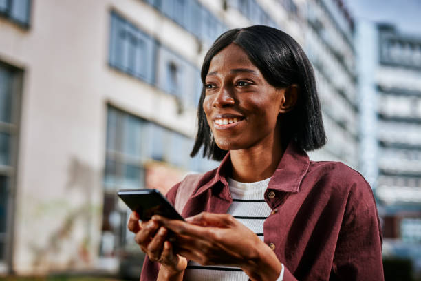 istock Woman walking and typing on the phone in downtown 1406891408