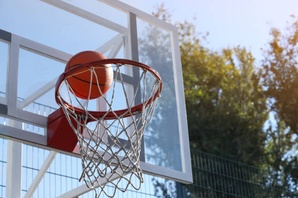 istock Basketball ball and hoop with net outdoors on sunny day 1406891522