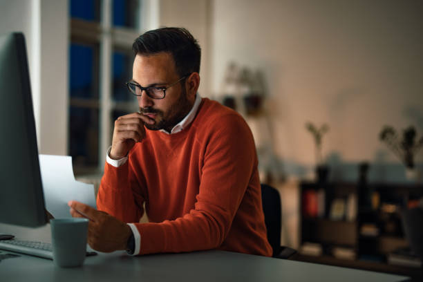 istock Serious-looking man checking some papers, working at the office, 1406891670