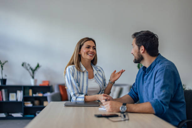 istock Two ambitious people talking to each other at the office. 1406892454