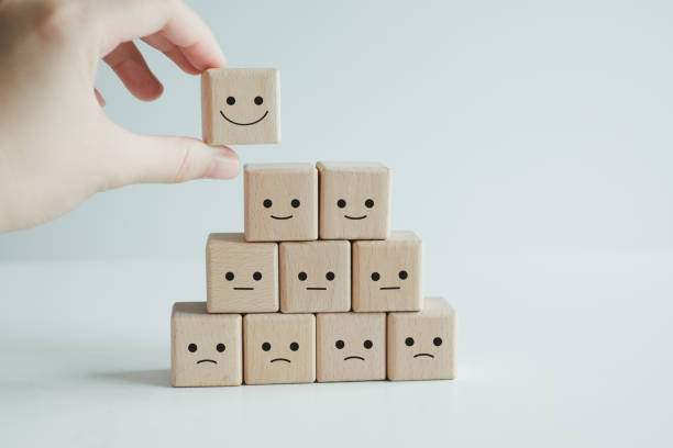 istock Customer service evaluation and satisfaction survey concepts. The client's hand picked the happy face smile face symbol on wooden blocks. 1406892685