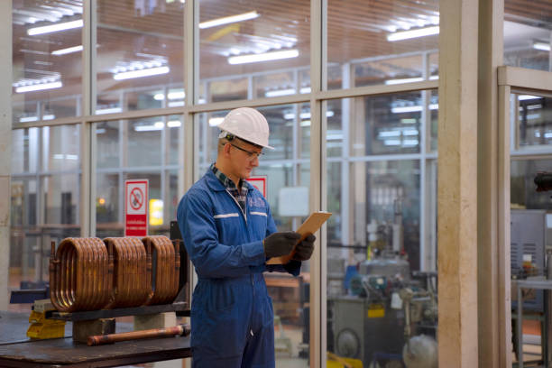 istock Blue collar worker works machine at factory. 1406895927