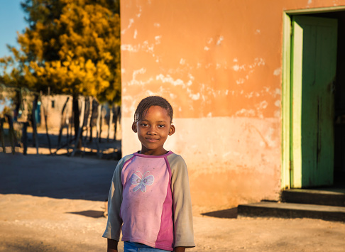 portrait of a smiling African girl with pink blouse at sunset in a village in Africa