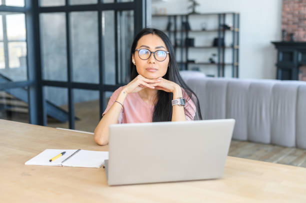 istock Thoughtful Asian creative designer in glasses 1406897910