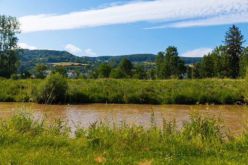 the river sure seen from bettendorf in luxembourg with the rolling countryside and blue sky with white clouds as background