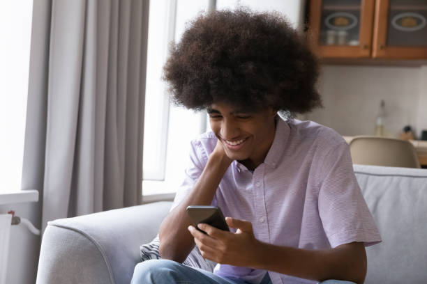 istock Happy teenage Black student guy typing message on smartphone 1406899799
