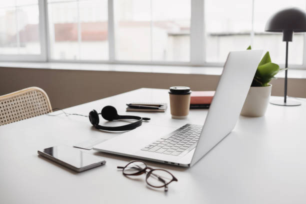 istock Place of work. Eyeglasses and laptop on a table at home 1406899990