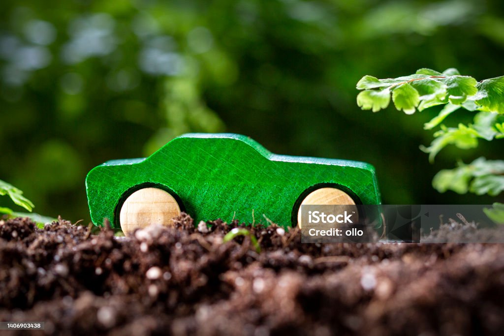 Wooden toy car in the nature - concept of sustainable mobility Greenhouse Gas Stock Photo